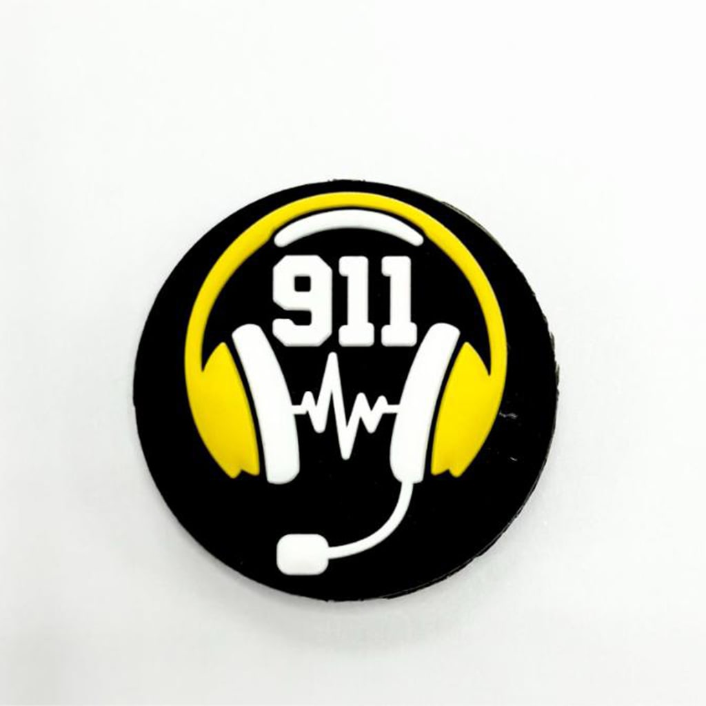 A silicone bead featuring the 911 emergency number with a graphic of a telephone and heads sets in yellow and black on a white background.