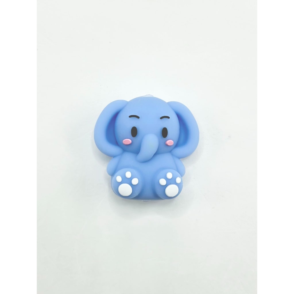 A silicone bead in the shape of a blue elephant with a smiling face and white accents on the feet.