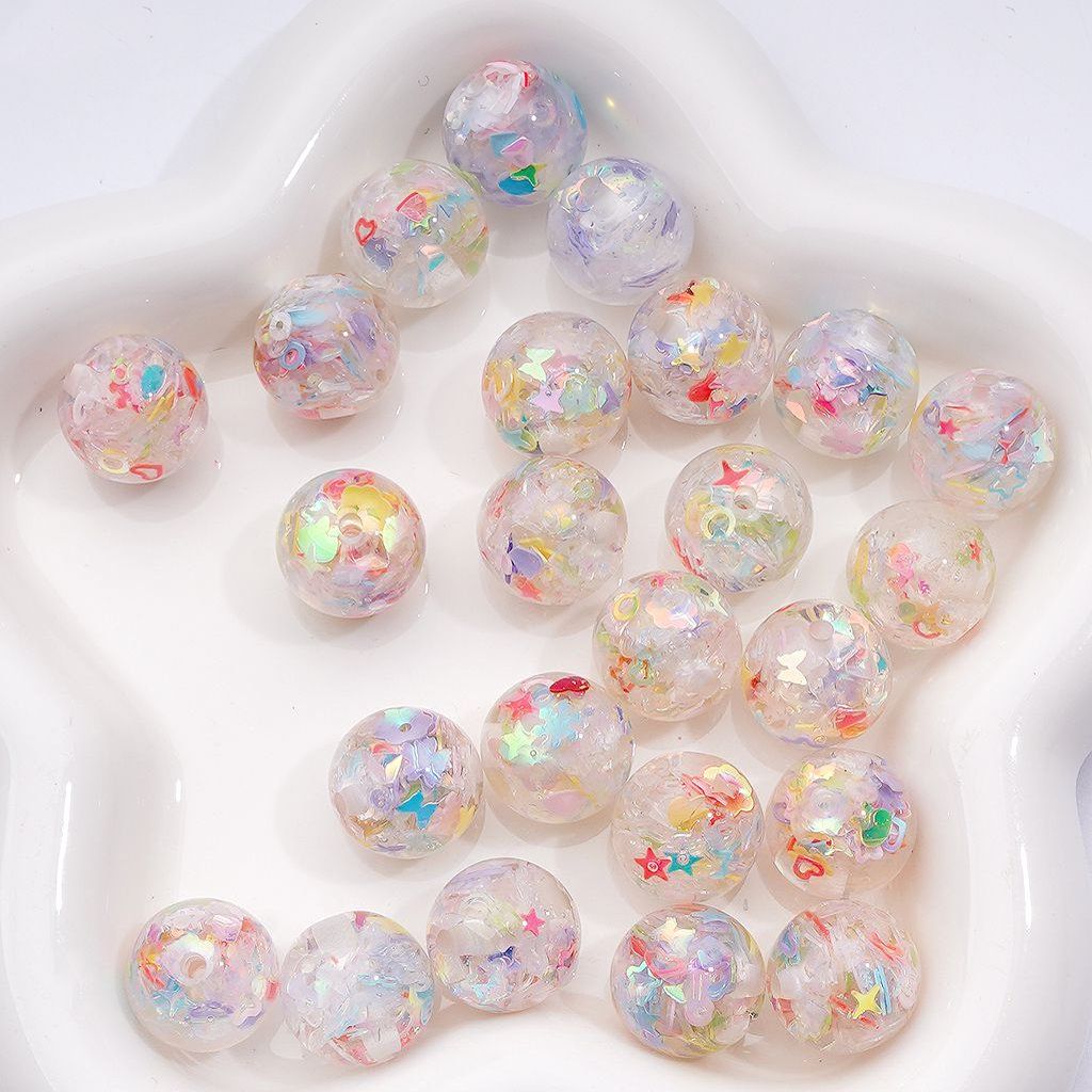 Iridescent beads with star and heart patterns on a white surface