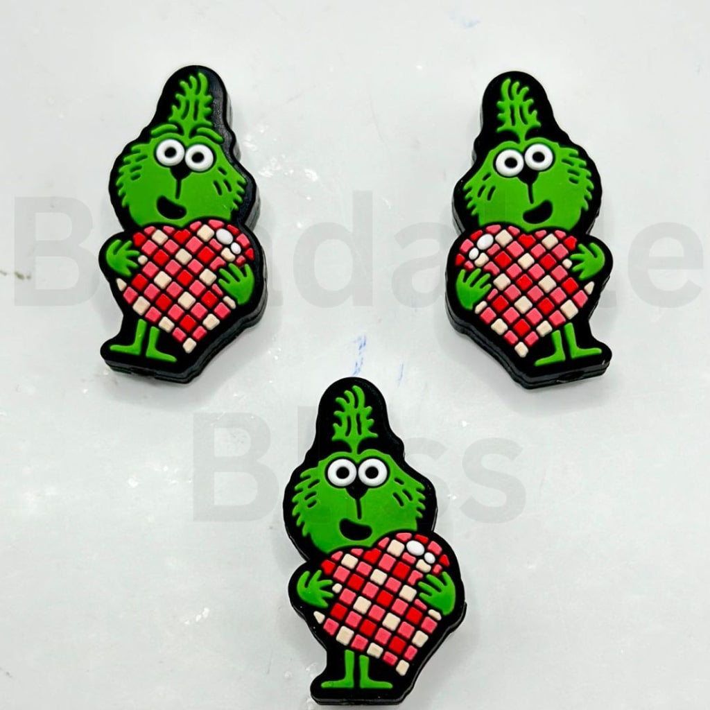 ミニかわいい緑の赤ちゃんの男性が大きな赤いチェック柄のハートのシリコン製フォーカルビーズを持っています