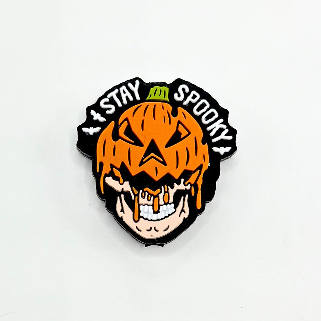 A silicone bead with a design of a pumpkin and a skeleton face, and the text 'STAY SPOOKY'.