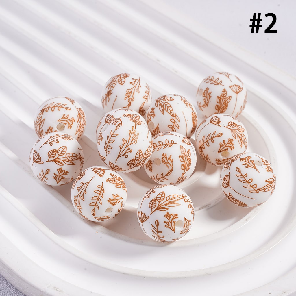 White spherical candies with gold floral patterns on a white plate