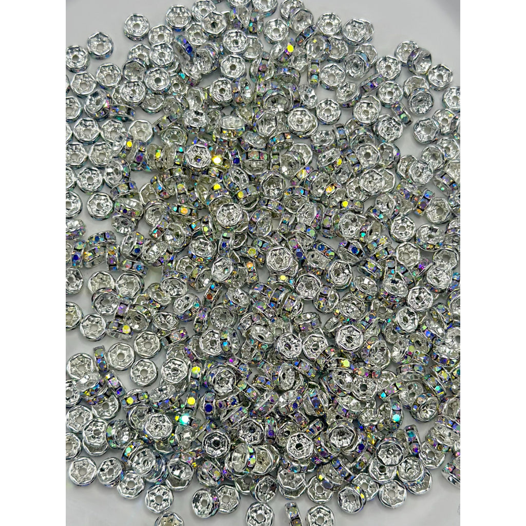 A collection of flat round metal spacers with multicolored rhinestones