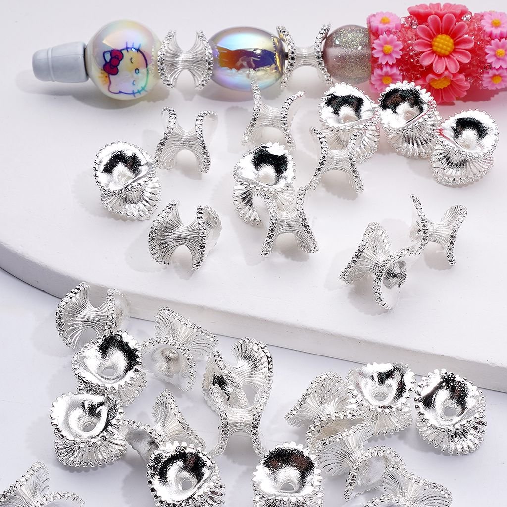 Silver jewelry components on a white surface with colorful beads in the background