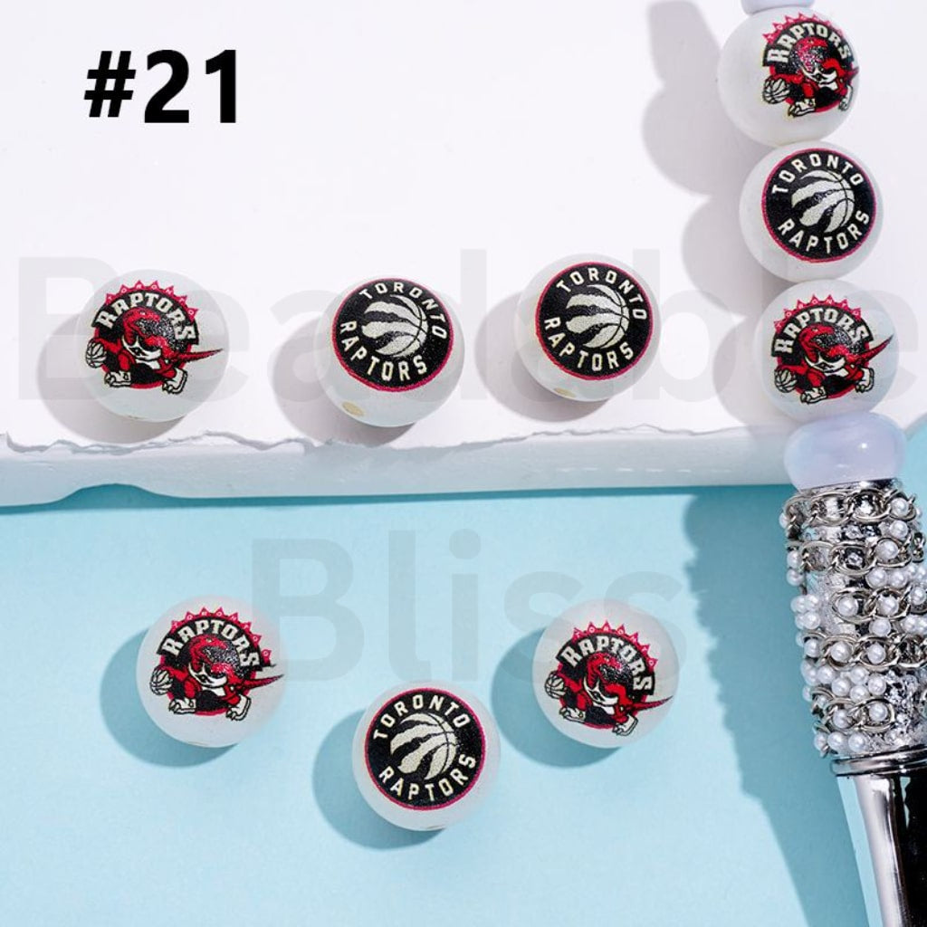 Collection of Toronto Raptors earrings on a light blue background with a decorative object.