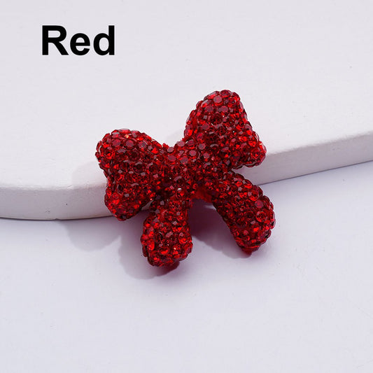 Red bow-shaped jewelry piece on a white background


