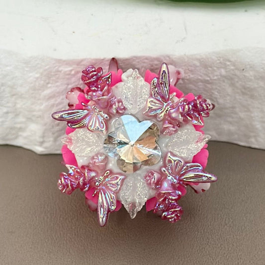 A collection of colorful floral decorations with rhinestones and white clay beads.


