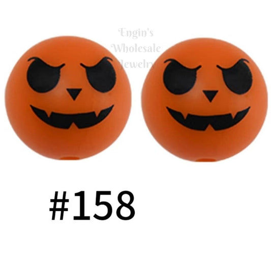 Two orange balls with black jack-o'-lantern faces on a white background.

