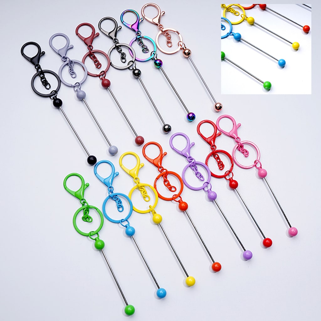 A collection of colorful metal keychains with beadable designs and lobster clasps.

