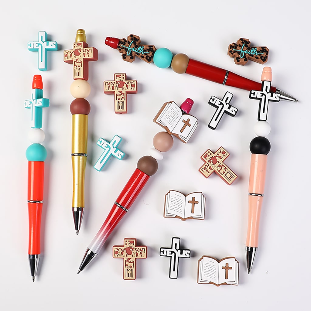 Colorful pens and religious-themed pins on a white background