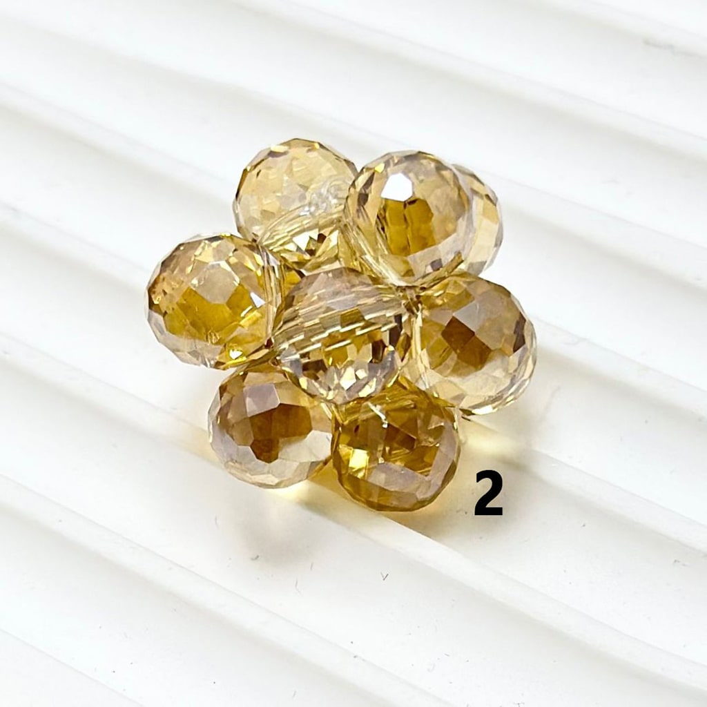 Cluster of faceted yellow beads on a white background

