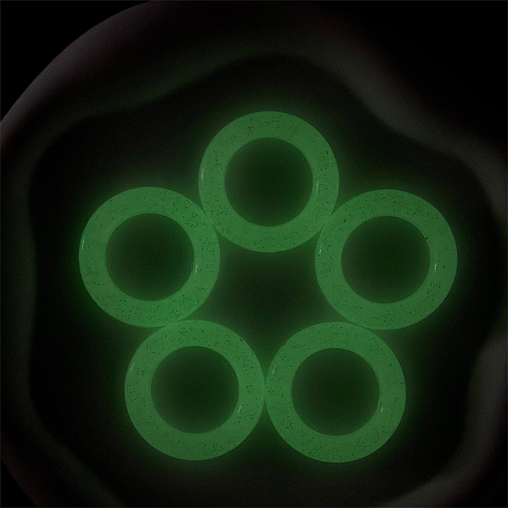 Five green rubber rings arranged in a circular pattern on a dark background

