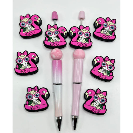 メガネと蝶結びをしたかわいい小さなカメが、ピンクのフラミンゴのシリコン製フォーカルビーズの上に座ってます