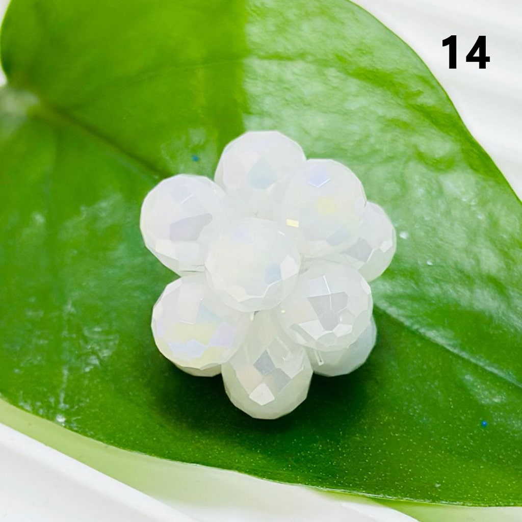 White flower-shaped object on a green leaf with number 14 in the corner

