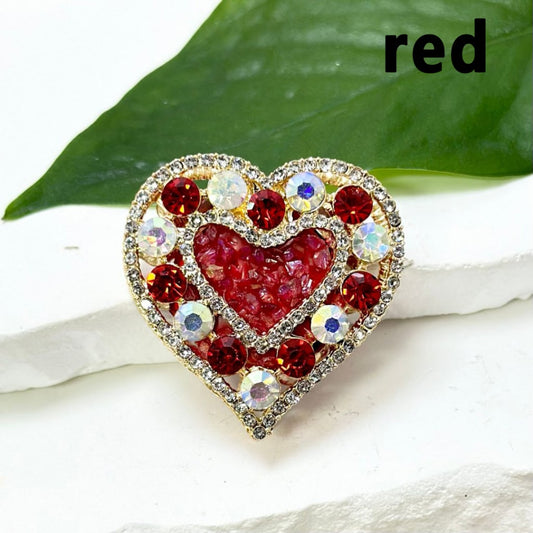 A collection of gold alloy heart-shaped pendants, each adorned with colorful rhinestones, small stones, oval pearls, and clay beads.

