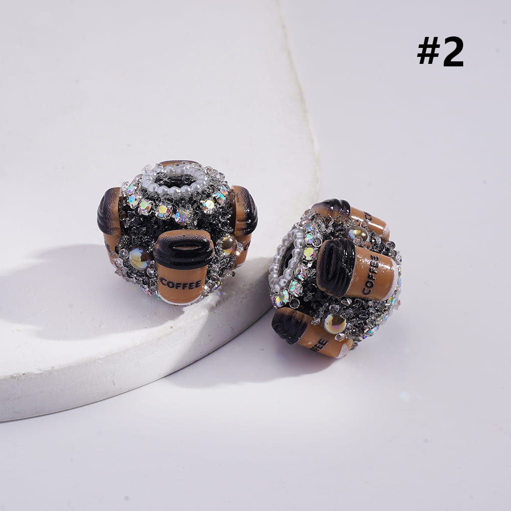 Pair of coffee-themed earrings on a white surface with a light gray background