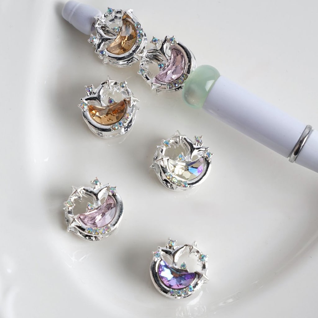 Silver alloy beads with crescent moon and stars designs, featuring multicolored rhinestones.

