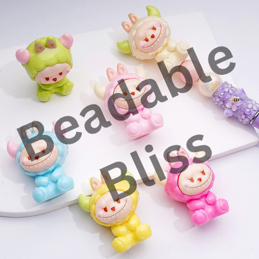 Colorful cow-shaped hair accessories on a white surface with 'handsontsupply.com' text.