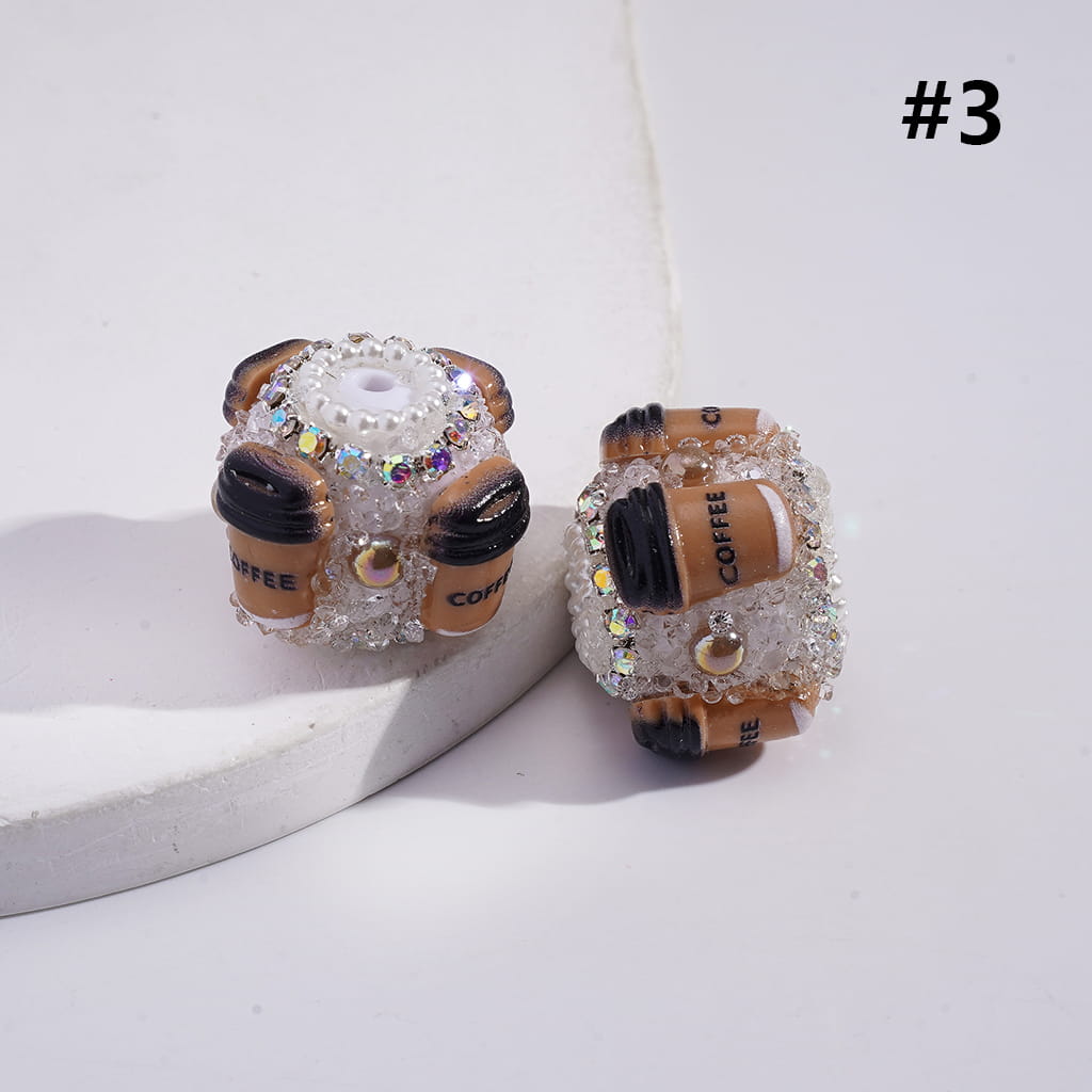 Decorative earrings resembling coffee cans with rhinestones on a light background