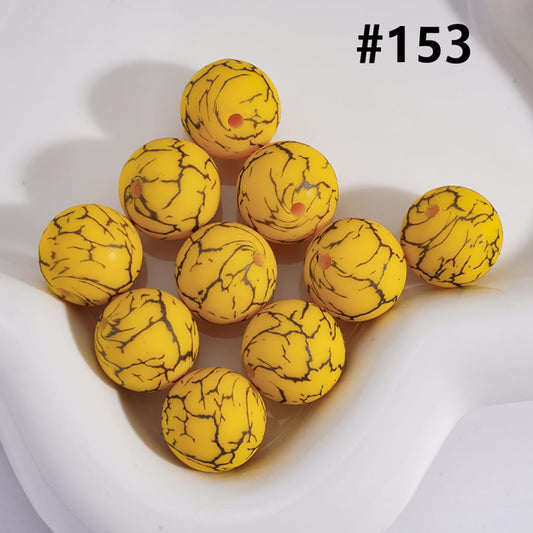 Yellow marbled balls on a white surface with the number #153.