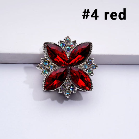 A collection of silver alloy four leaf clover-shaped beads with colorful and AB rhinestones attached to them.

