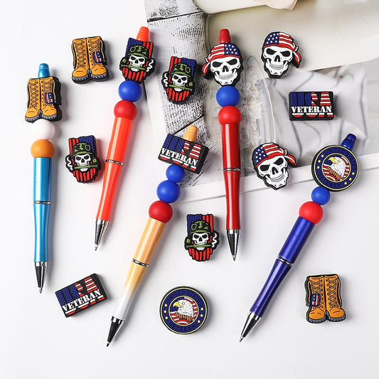 Collection of pens and pins with various designs on a white background

