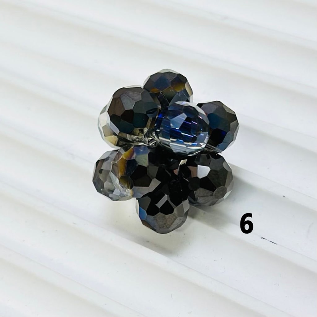 Jewelry piece with blue and black gemstones on a white background

