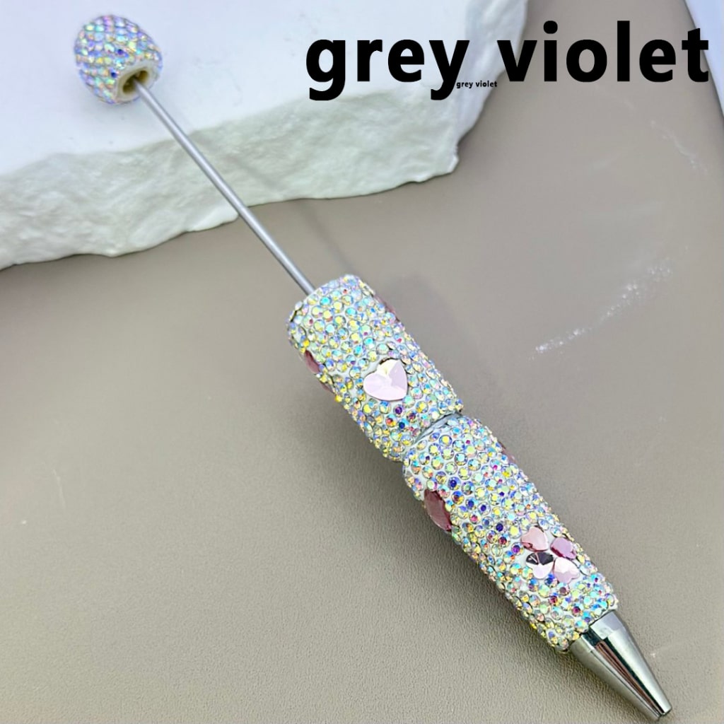 Decorative pen with gemstones on a neutral background