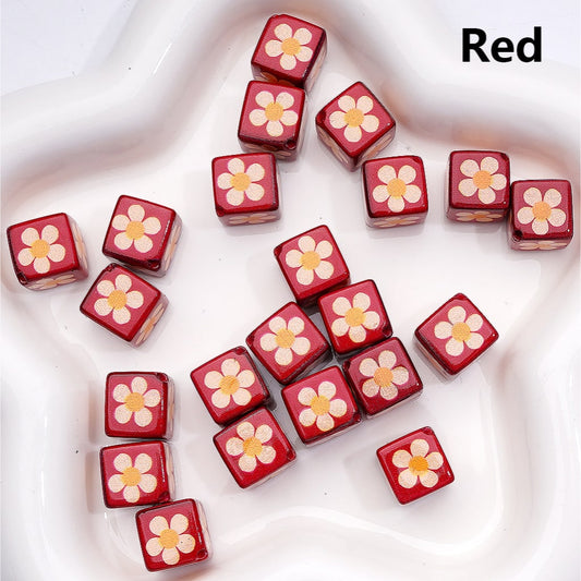 Red dice with flower designs on a white surface

