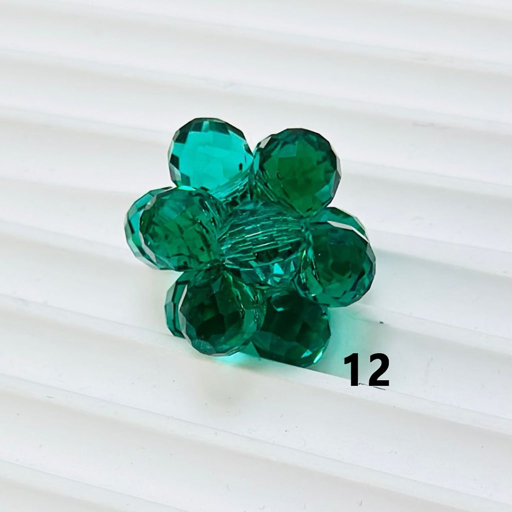 Green glass flower bead on a white background


