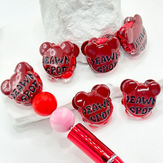 A collection of multicolored beads in the shape of Mickey and Minnie Mouse heads, featuring rhinestones and pearls.

