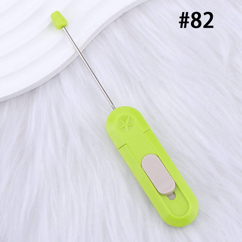 Green handheld tool with a white button on a white background