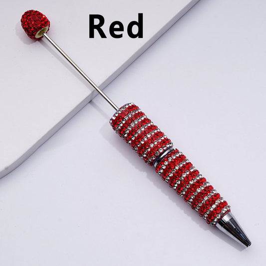 Decorative pen with red gemstones on a white background

