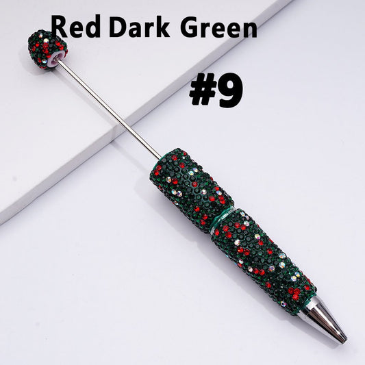 Decorative pen with red and green gemstones on a white background

