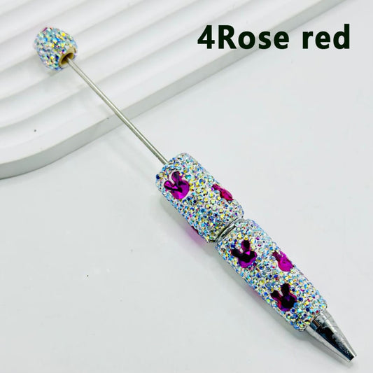 A set of colorful pens with decorative rhinestones and beadable clay covers on the tips.

