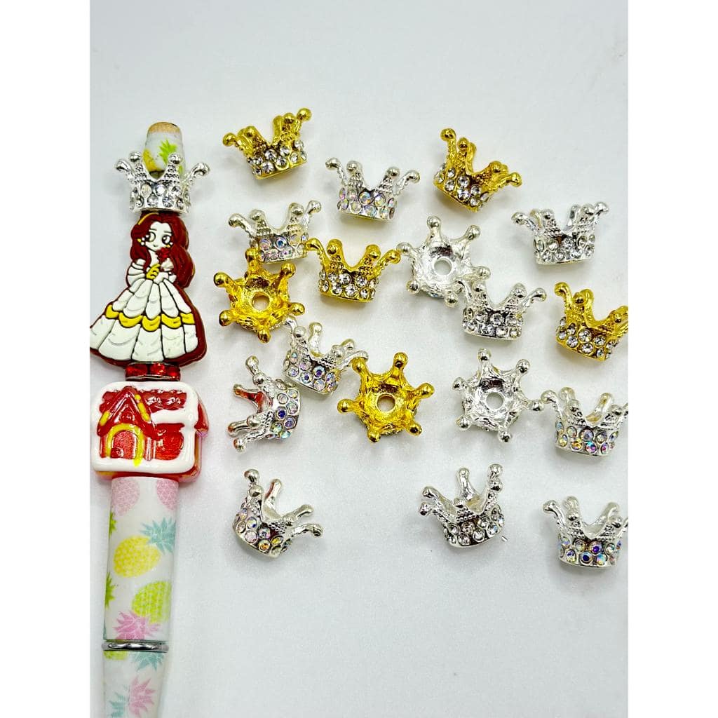 A collection of clear rhinestones set in gold and silver alloy metal crown shapes.


