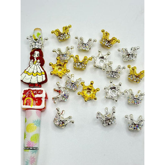 A collection of clear rhinestones set in gold and silver alloy metal crown shapes.

