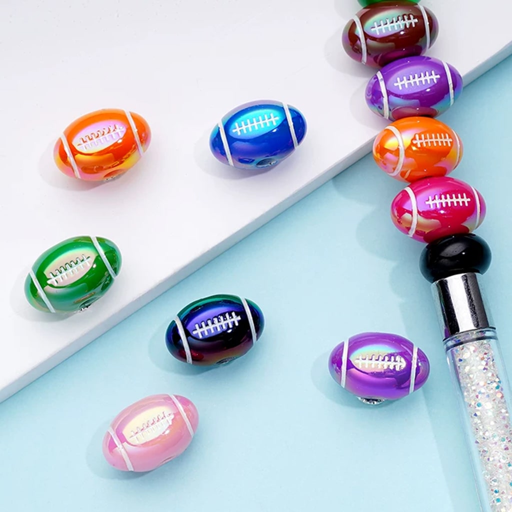 Colorful football-shaped beads on a white tray with a light blue background

