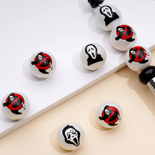 Acrylic beads with a red and black design resembling a ghost on a white background, used for crafting.

