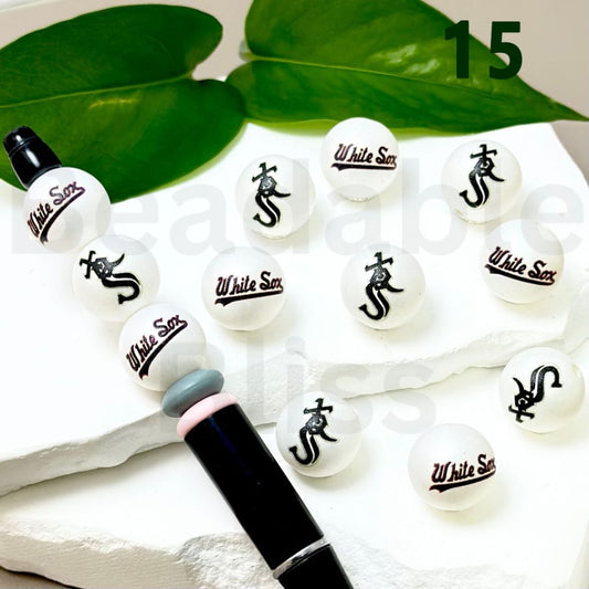 White Sox lip balm with black logo on a white surface with green leaves in the background

