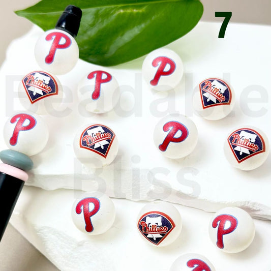 White balls with red 'P' and blue logo on a white surface with green leaves.

