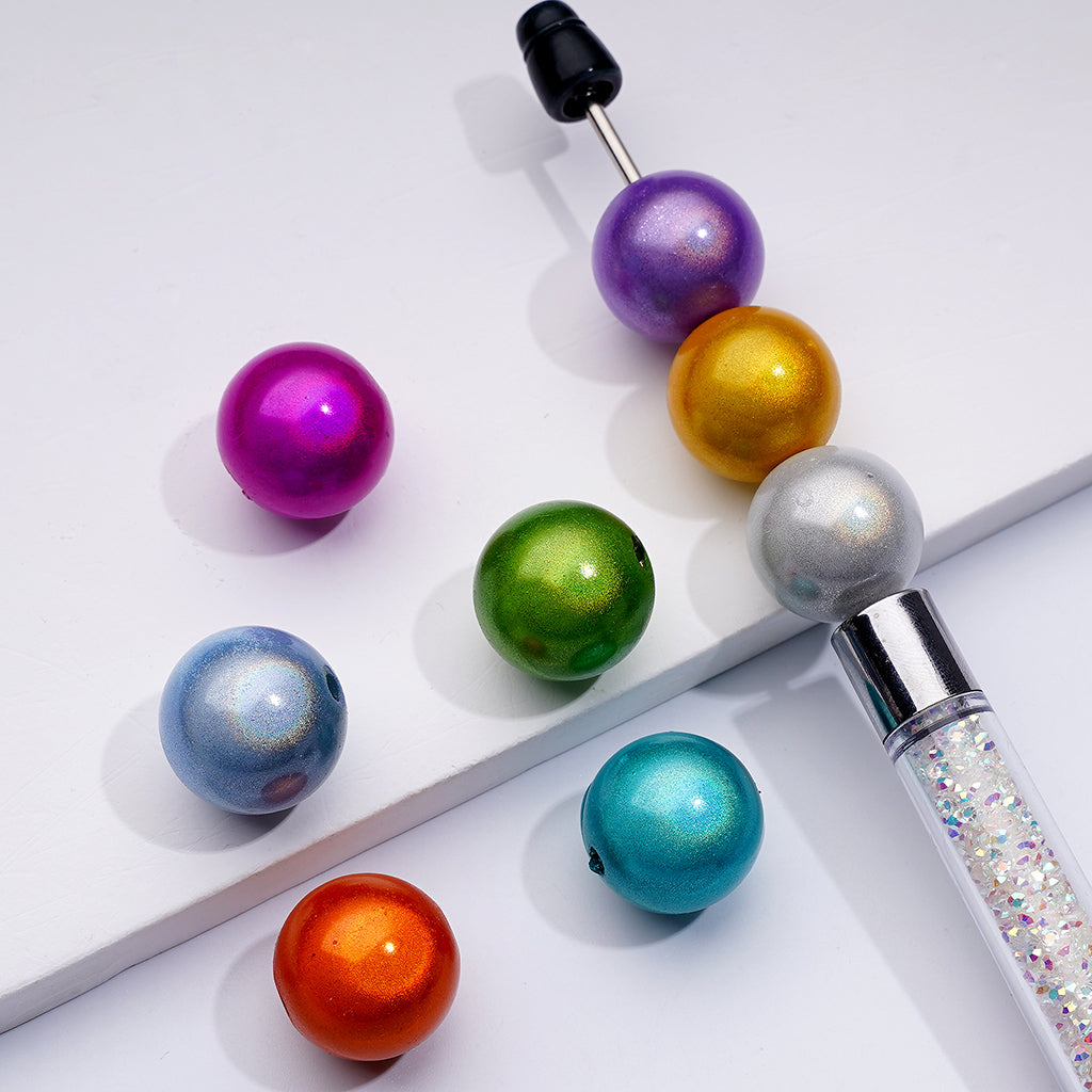 A collection of colorful shiny round acrylic beads in various colors displayed alongside a beadable pen.

