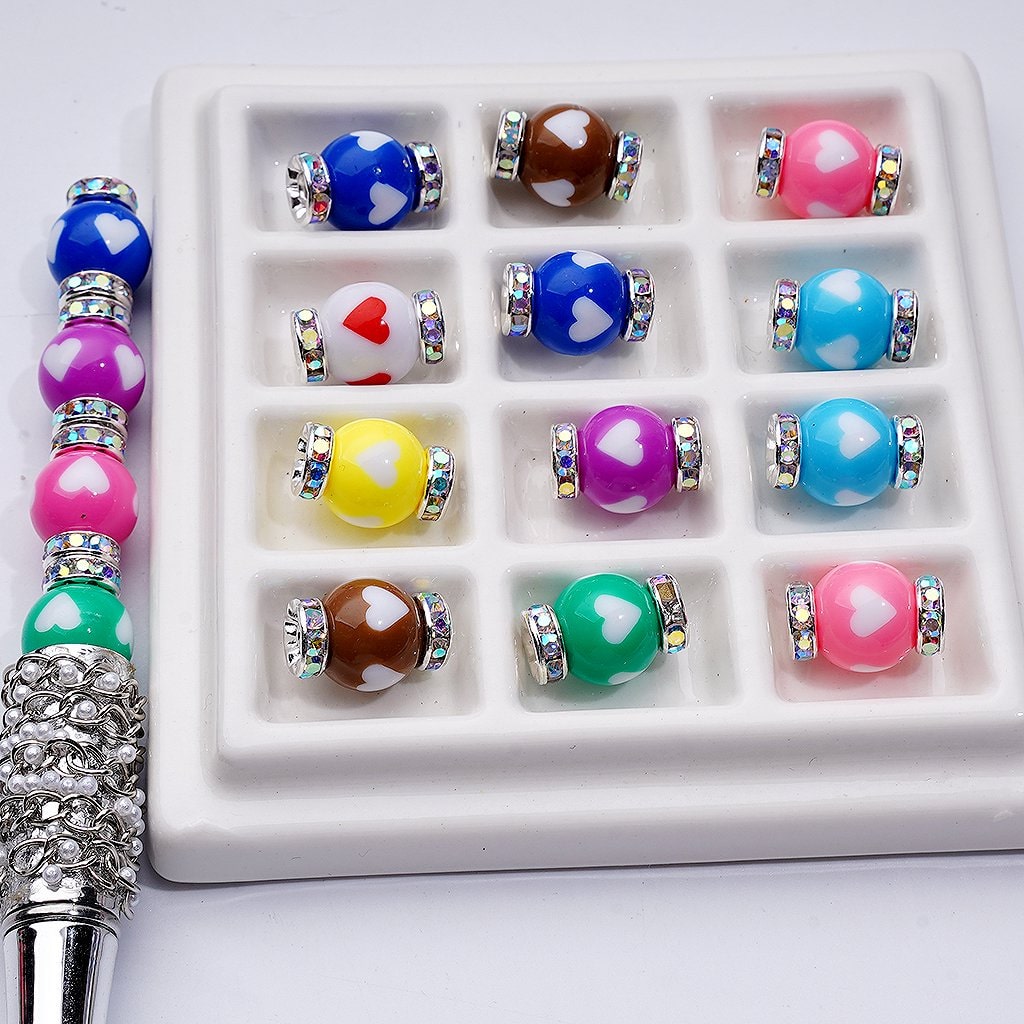 Colorful beaded bracelets with heart designs on a white tray

