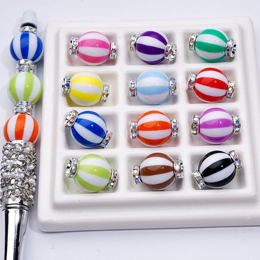Set of colorful striped beads with a metal tool on a white background


