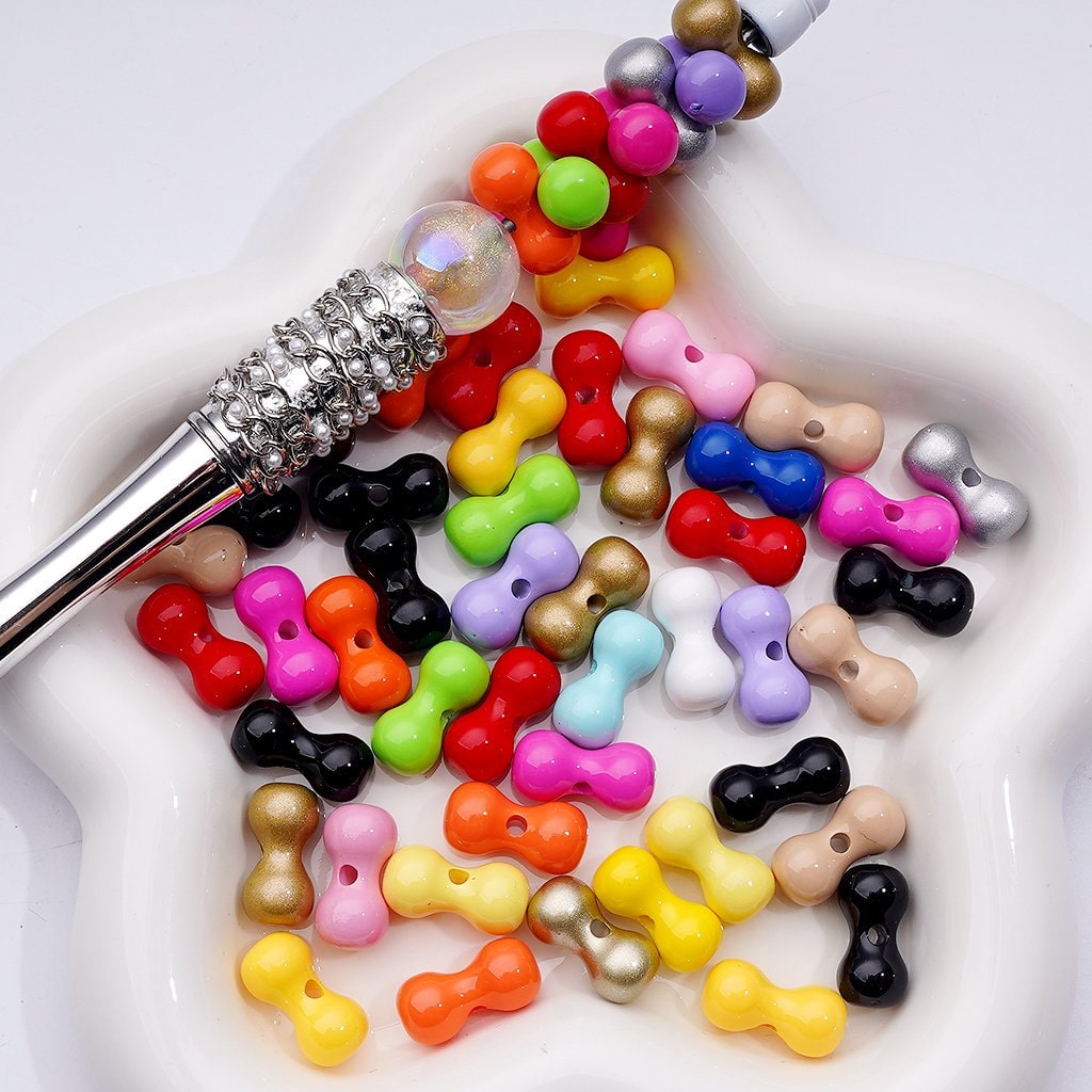 Colorful bow-shaped beads on a white plate with a makeup brush.

