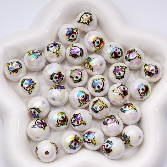 White beads with colorful fish designs on a white surface

