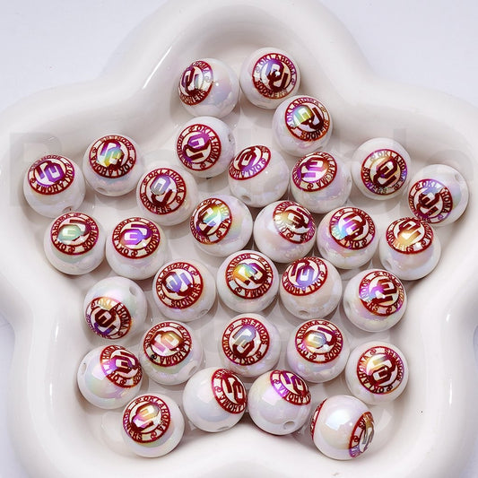 White beads with red and gold designs on a white background

