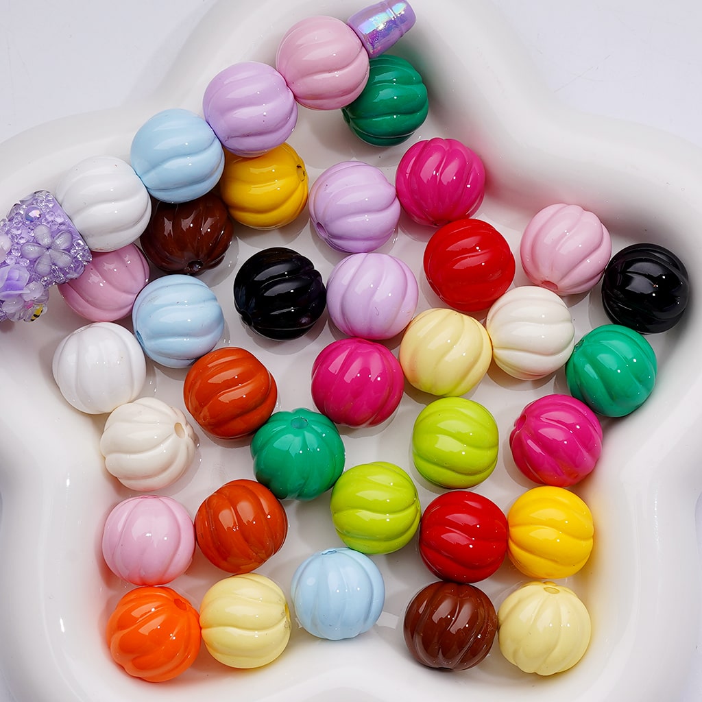 Assorted colorful round beads in a white container

