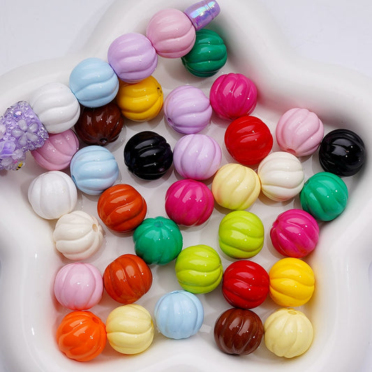 Assorted colorful round beads in a white container


