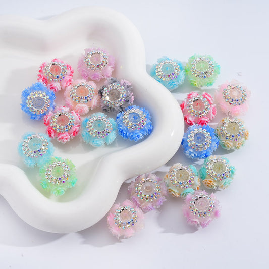Decorative beads with rhinestones and fluffy textures on a white dish

